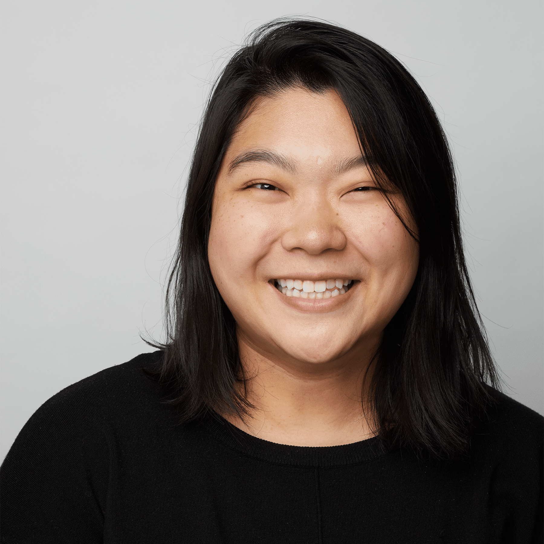 woman with black hair wearing a black shirt smiling