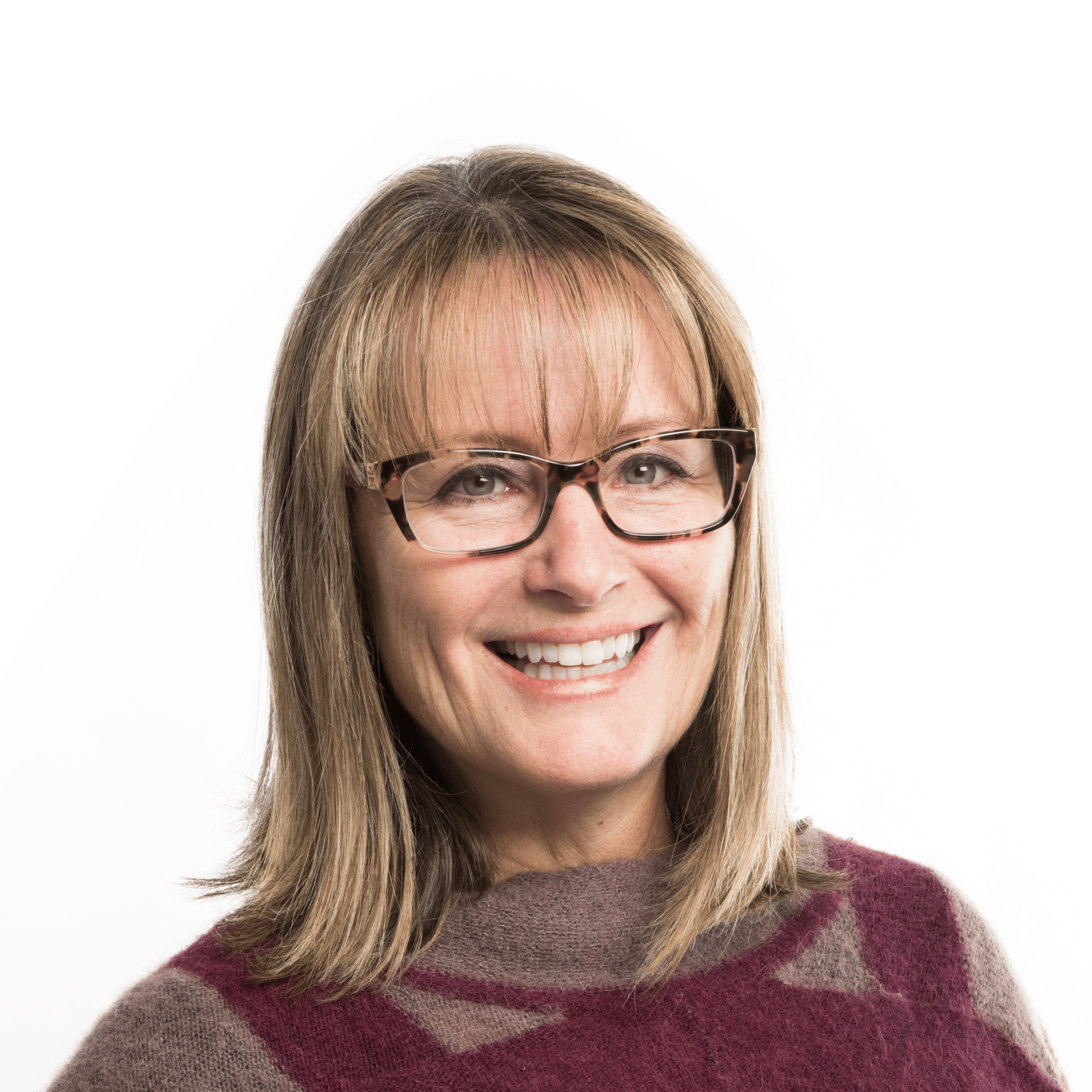 white woman with short blonde hair and glasses smiling.