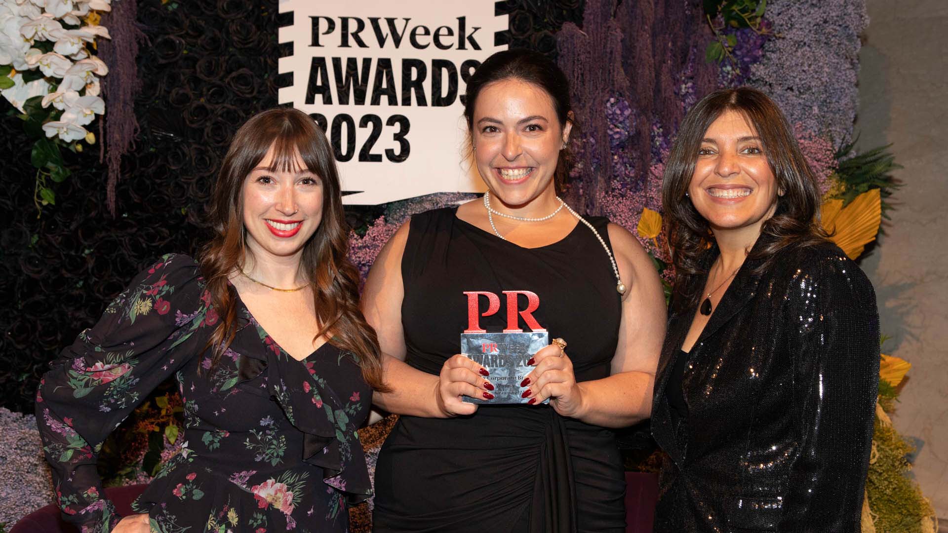 three women smiling after winning PR award