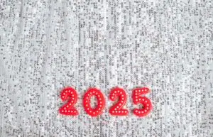 Red ‘2025’ numerals with white polka dots placed on a sparkly silver sequin background.