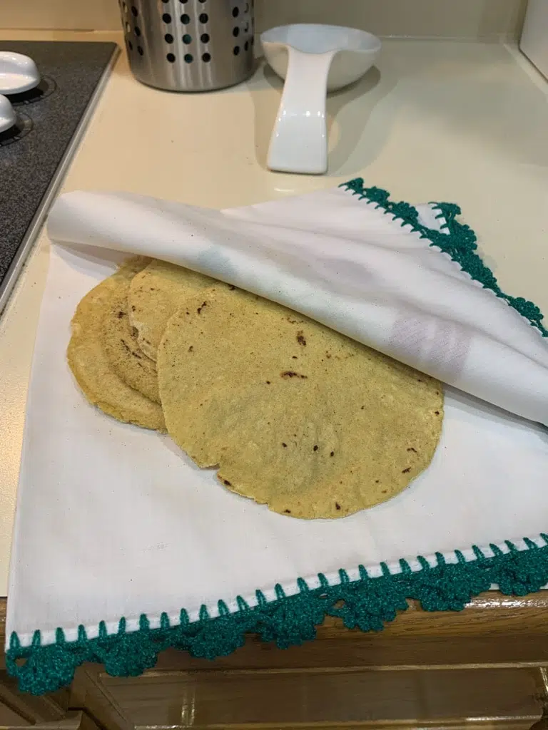 fresh tortillas wrapped in green and white cloth.