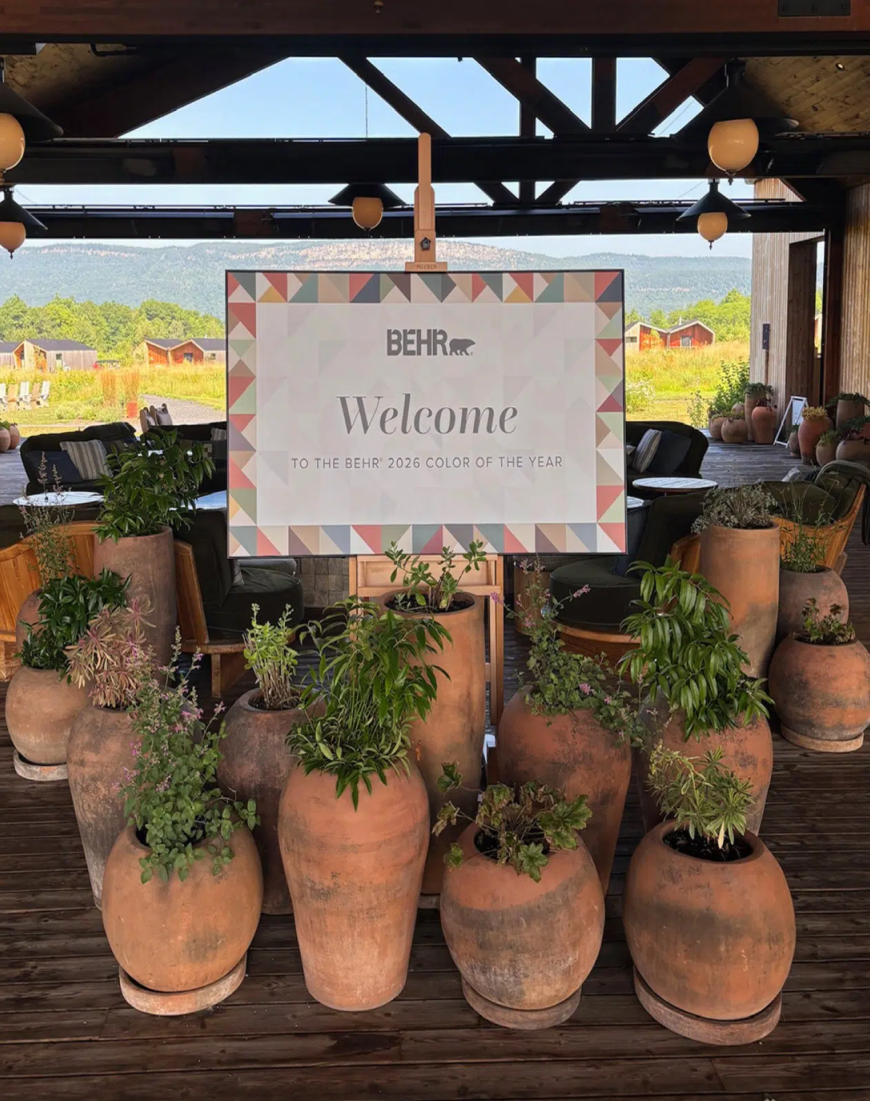 Behr welcome sign surrounded by potted plants at an outdoor Color of the Year event